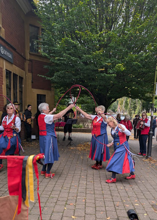 Nancy Butterfly dancing in Bournville Green amongst the atmospheric shops and trees