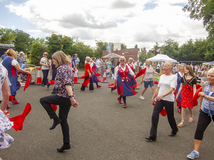 Volunteers enthusiastically joining in the dancing despite the heat