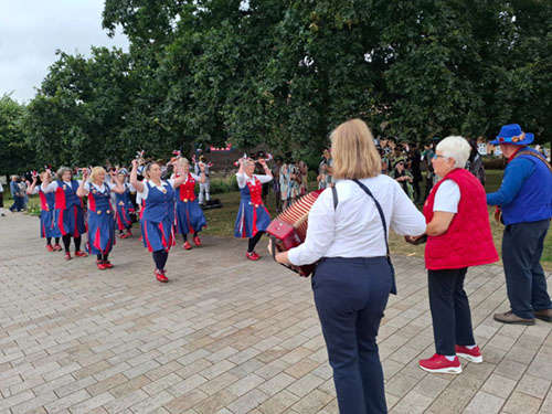The 3 members of the band play in front of 8 dancers in action