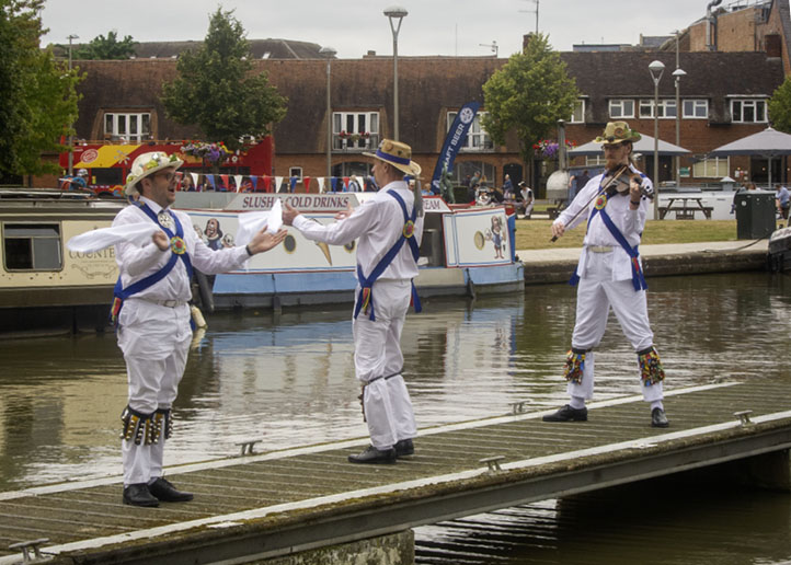 3 members of Jockey Morris dancing on a jetty in the canal basin