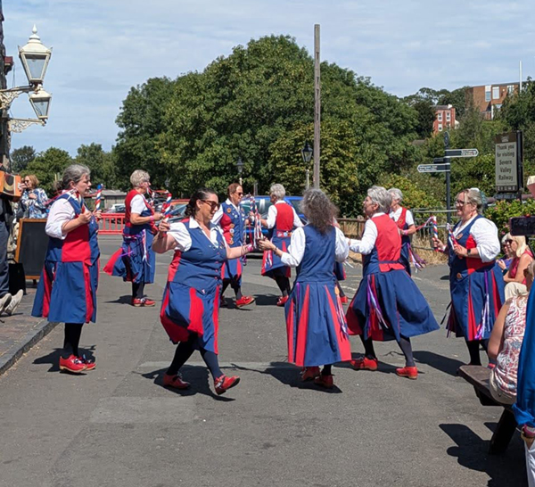 9 dancers performing in hot, bright, sunshine
